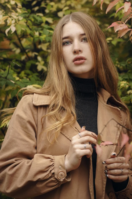 a beautiful young woman standing in front of a tree, trending on pexels, light brown coat, light brown hair, ((portrait)), autum