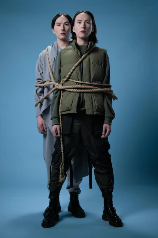 a couple of people standing next to each other, an album cover, unsplash, renaissance, rope bondage, combat vest, conjoined twins, studio photo