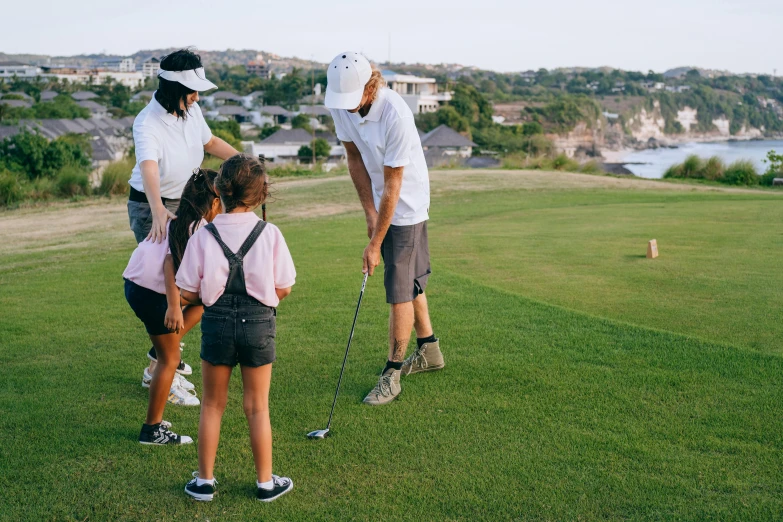 a group of people standing on top of a lush green field, golf course, avatar image, kids playing, lachlan bailey