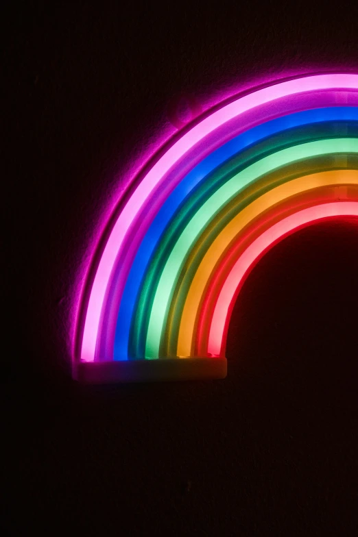 a rainbow is lit up in the dark, an album cover, by Rachel Reckitt, pexels, bright neon signs, istockphoto, lightshow, neon ligh