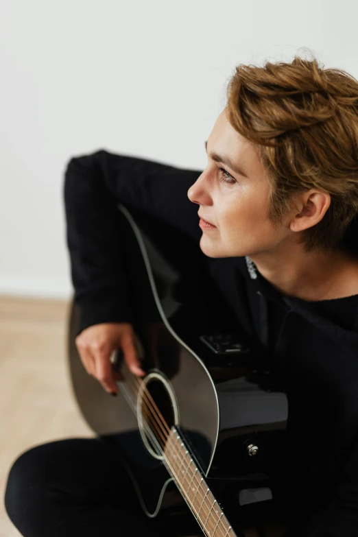 a man sitting on the floor with a guitar, androgynous face, profile image, caspar david, neck zoomed in