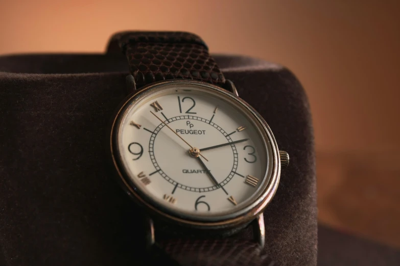 a close up of a watch on a hat, a portrait, unsplash, photorealism, taken in the early 1990s, odissey, gradient brown to white, peugeot prestige