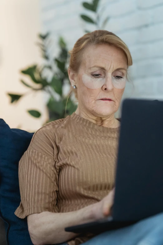 a woman sitting on a couch using a laptop computer, pexels, renaissance, ugly woman, digital screenshot, older woman, serious business