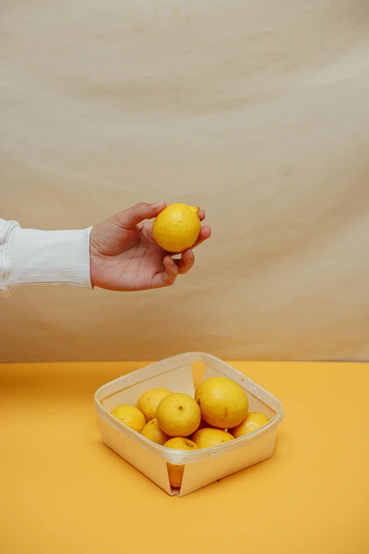 a person holding a lemon in front of a bowl of lemons, an album cover, unsplash, ilustration, semi-transparent, market, lulu chen