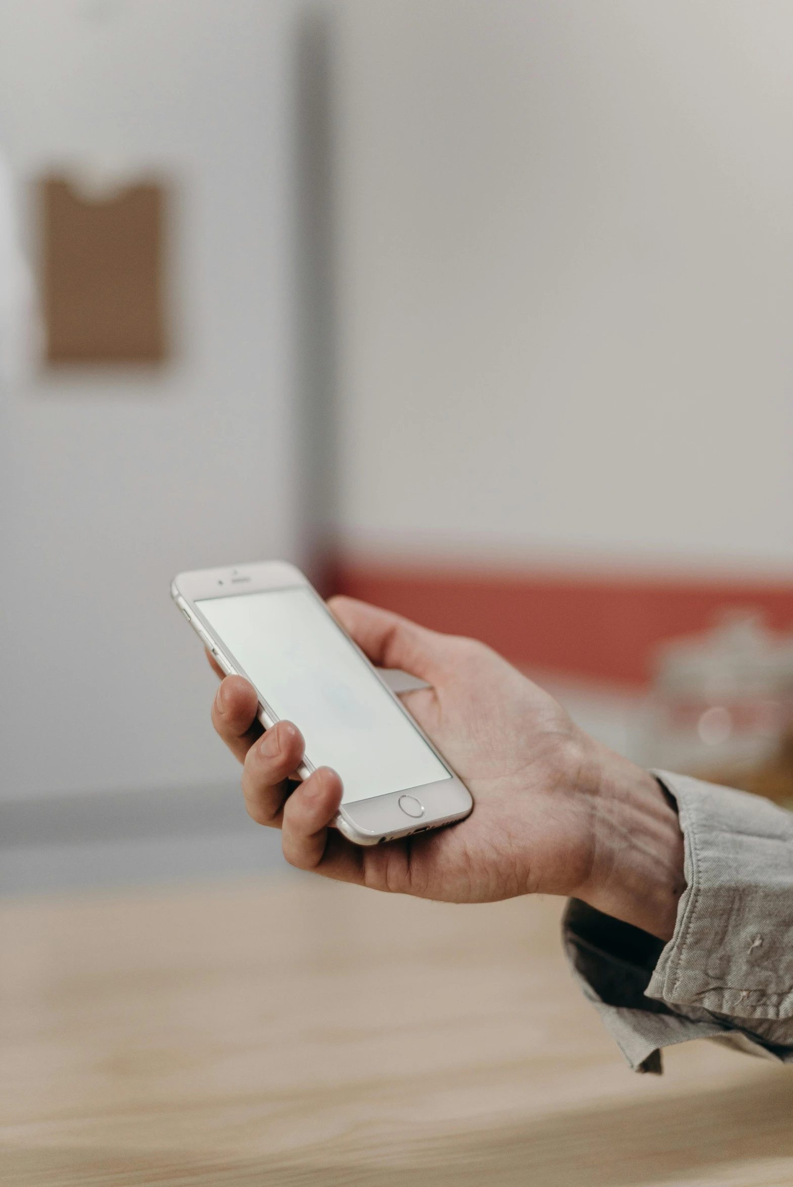 a close up of a person holding a cell phone, by Sven Erixson, happening, square, cardboard, white hue, indoor picture