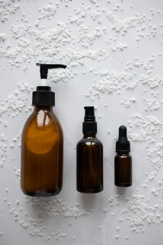 a couple of brown bottles sitting next to each other, unsplash, renaissance, skincare, spraying liquid, abomasnow, opaque glass