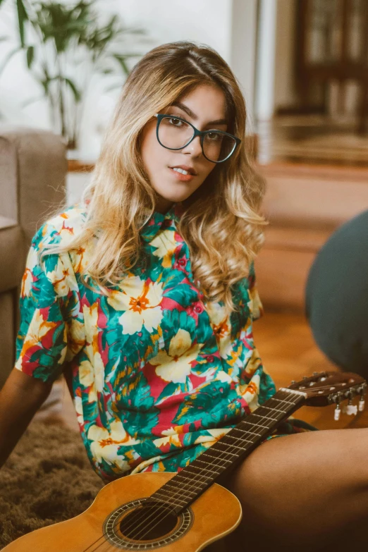 a woman sitting on the floor with a guitar, hawaiian shirt, yellow carrera glasses, zoomed in, julia sarda