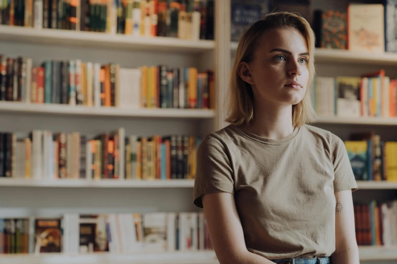 a woman sitting in front of a book shelf, inspired by Louisa Matthíasdóttir, pexels contest winner, hyperrealism, cara delevingne standing, soft lighting and focus, sydney sweeney, liminal bookshop