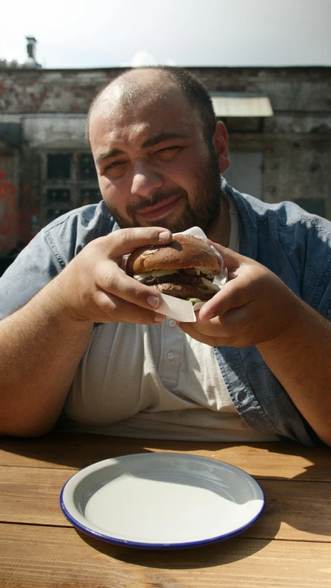 a man sitting at a table eating a sandwich, pexels, plus-sized, real life photo of a syrian man, 15081959 21121991 01012000 4k, lgbtq