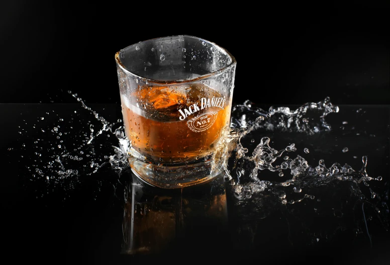 a glass filled with liquid sitting on top of a table, inspired by Jack Smith, pexels, photorealism, splashing, drinks bourbon, high quality product image”, three quarter shot