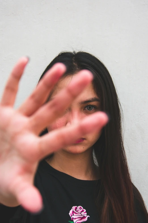 a woman making a stop sign with her hands, pexels, visual art, violence in her eyes, headshot profile picture, 18 years old, close-up of thin soft hand