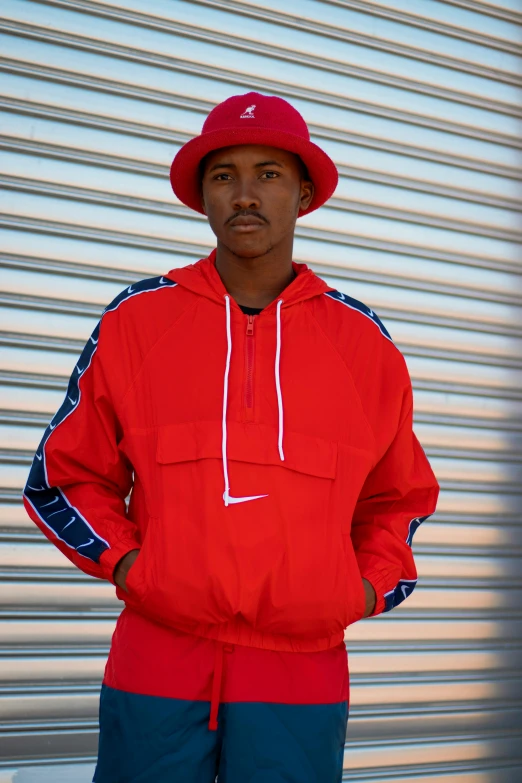 a man in a red jacket and a red hat, featured on dribble, in style of tyler mitchell, wearing a track suit, swoosh, promo image