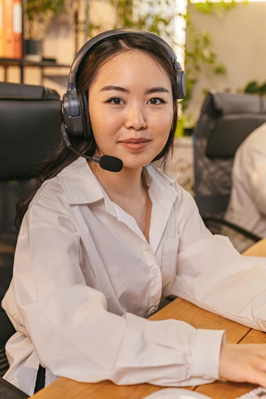 a woman sitting at a desk in front of a computer, with head phones, south east asian with round face, pokimane, order