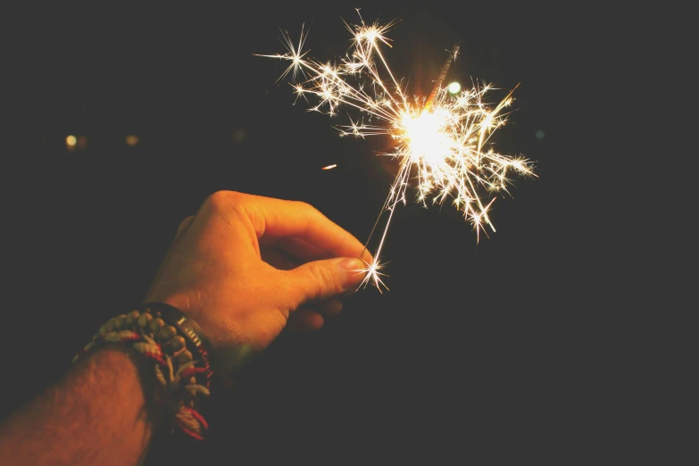 a person holding a sparkler in their hand, pexels, retro stylised, instagram post, bright stars, new years eve