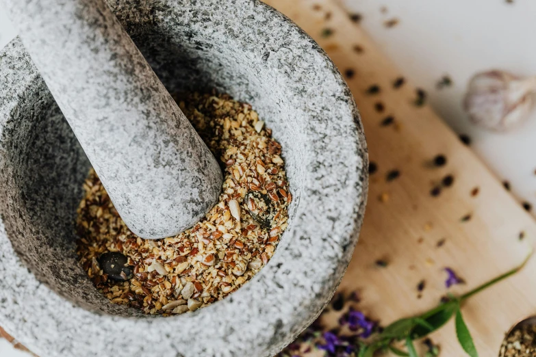a mortar filled with spices sitting on top of a cutting board, by Julia Pishtar, trending on pexels, renaissance, gravel and scree ground, lavender, crisp details, thumbnail