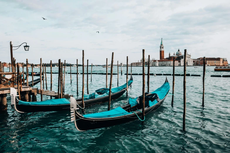 a couple of gondolas sitting on top of a body of water, inspired by Francesco Guardi, pexels contest winner, teal aesthetic, the three moiras, 🦩🪐🐞👩🏻🦳, conde nast traveler photo