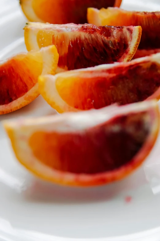 blood oranges cut in half on a white plate, slide show, vivid ember colors, red contact lenses, full-color