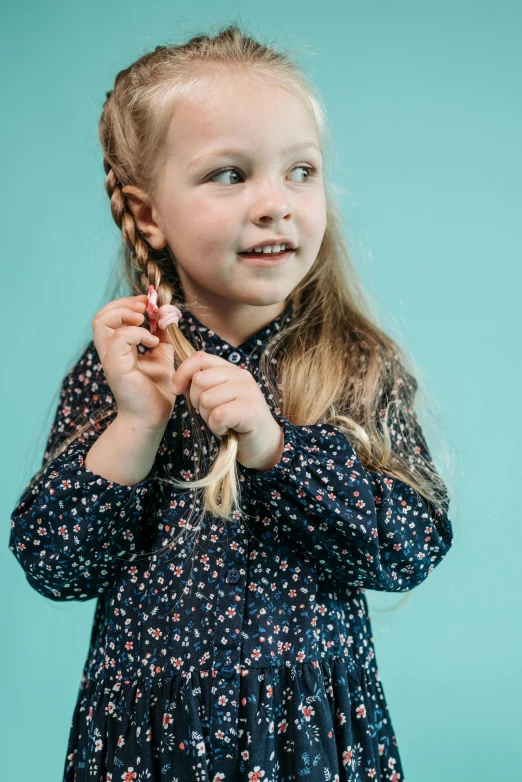 a little girl with a braid in her hair, an album cover, pexels, tiny sticks, happy fashion model, hands in her hair. side-view, navy