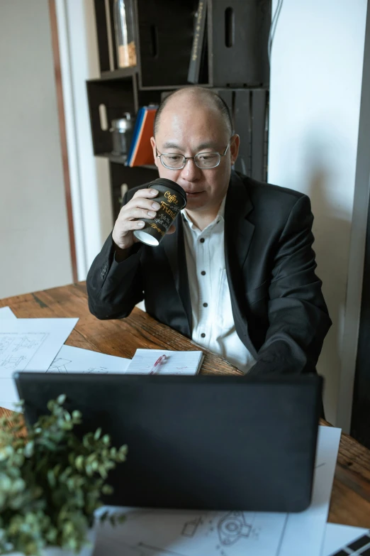 a man sitting at a table in front of a laptop, paul lung, holding a mug of beer, profile image, bald man