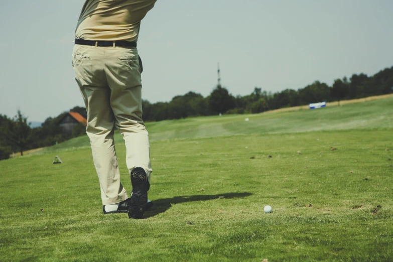 a man swinging a golf club at a golf course, pexels contest winner, wearing pants and a t-shirt, hyperdetailed!, gold, grainy