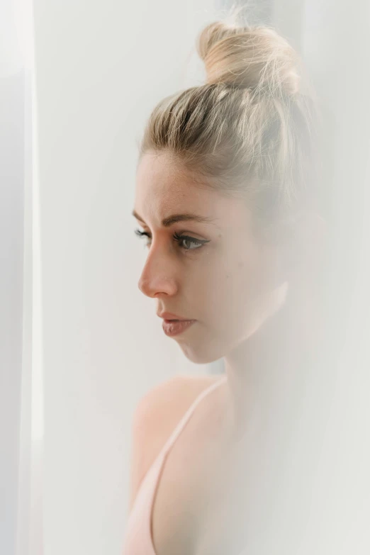 a woman looking at her reflection in a mirror, trending on unsplash, soft light misty, looking serious, white backdrop, portrait image