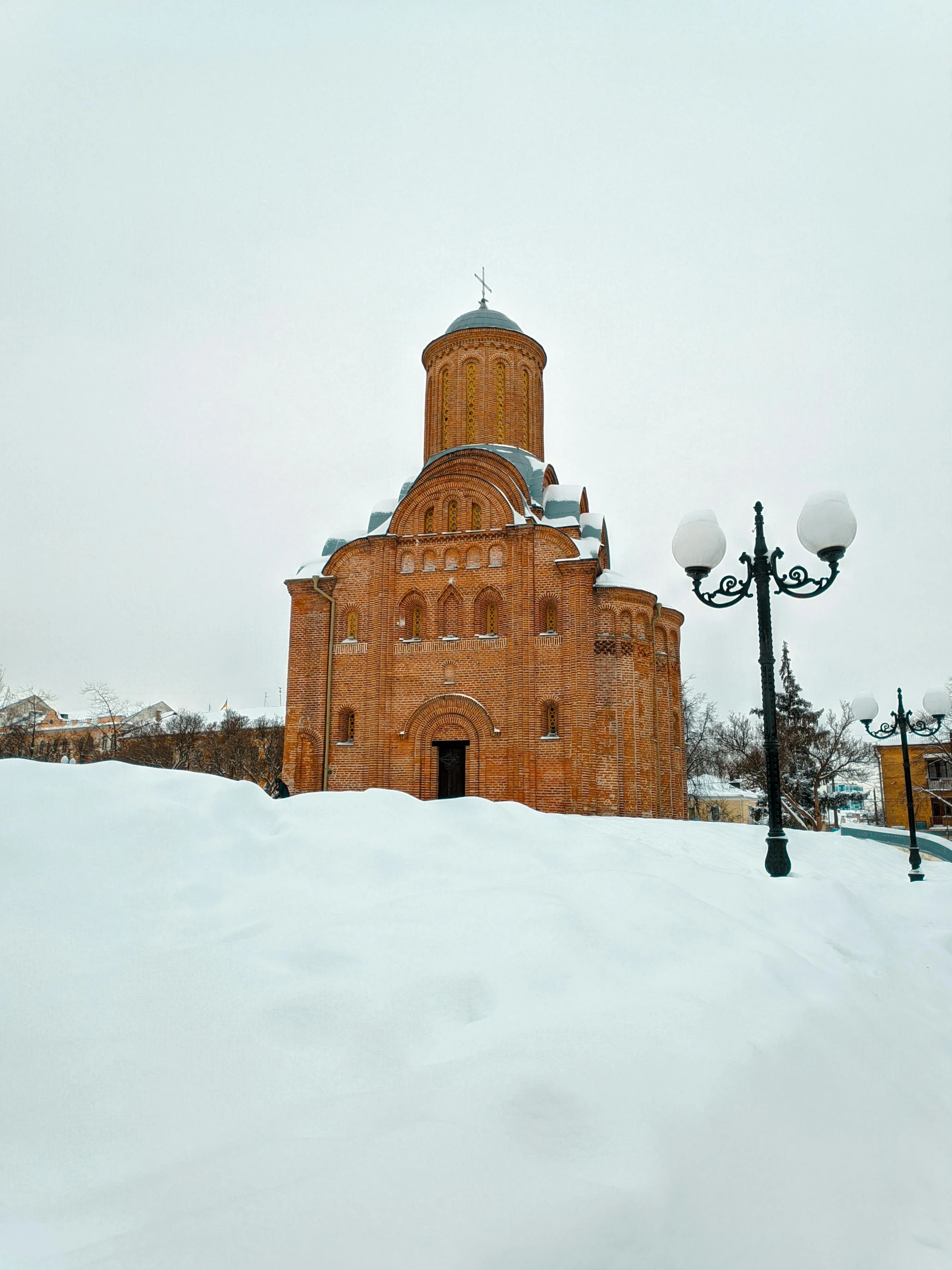 a church sitting on top of a snow covered hill, an album cover, inspired by Vasily Surikov, pexels contest winner, romanesque, exterior view, square, 000 — википедия, orange