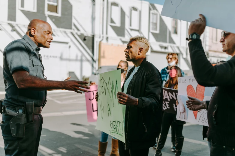 a group of people holding signs on a city street, pexels contest winner, black arts movement, two men, profile image, holding court, alana fletcher