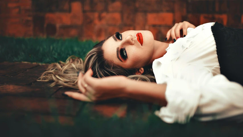 a woman laying on the ground next to a brick wall, a photo, trending on pexels, aestheticism, deep red lips, sexy face with full makeup, retro stylised, girls