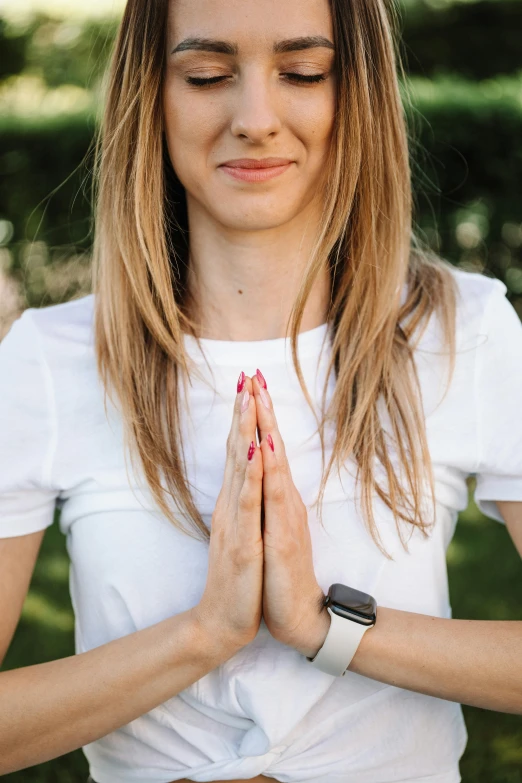 a woman in a white shirt is meditating, trending on pexels, holding holy symbol, a blond, corrected hands, confident looking