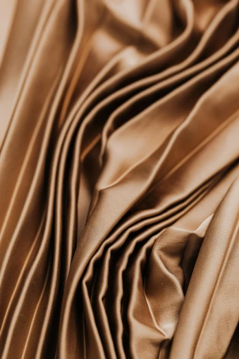 a close up of a brown satin material, inspired by Christo, trending on pexels, coated pleats, golden dappled dynamic lighting, instagram post, bronze