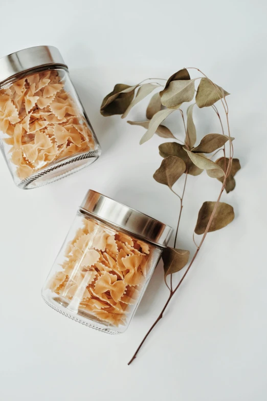 a couple of jars sitting on top of a table, intricate pasta waves, collection product, leafs, vanilla