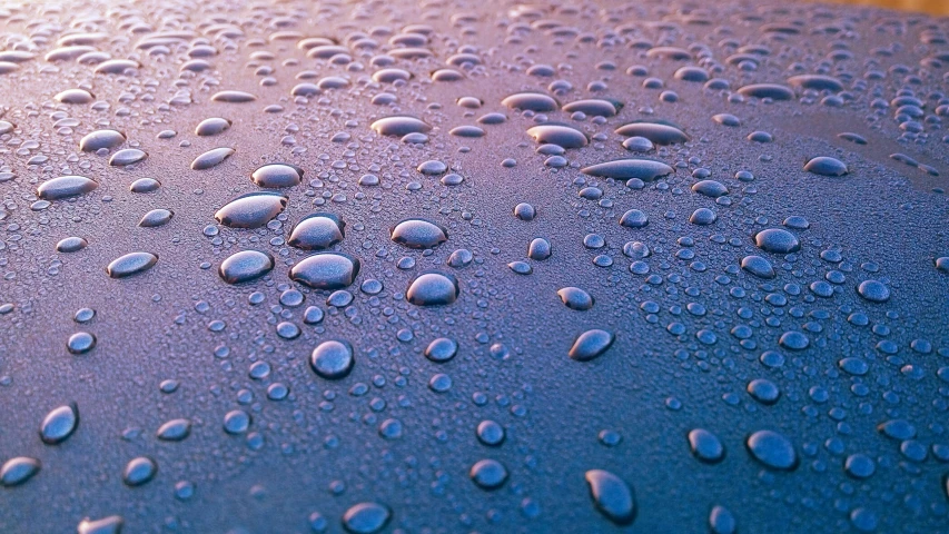 a close up of water droplets on the hood of a car, a macro photograph, by Jan Rustem, blue and purple, water on the floor, matte surface, low-angle shot