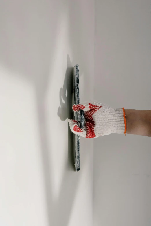 a person painting a wall with a paint roller, by artist, unsplash, hyperrealism, wearing gloves, holding scale, on display, no tiling