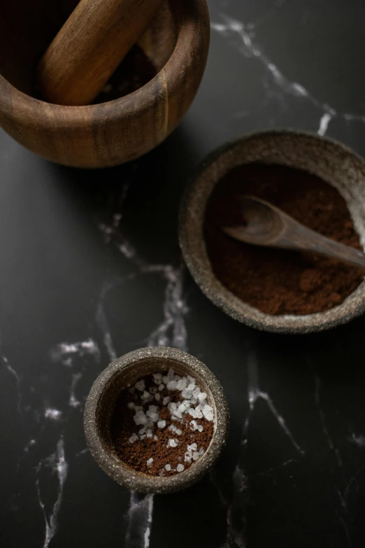 a close up of a bowl of food on a table, a still life, inspired by Henriette Grindat, trending on unsplash, dau-al-set, powdered sugar, dark brown, pepper no. 3 5, hand carved brown resin