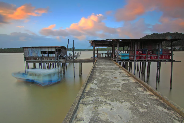 a boat that is sitting in the water, by Peter Churcher, hurufiyya, wood pier and houses, vivid sky, ren heng, overcast