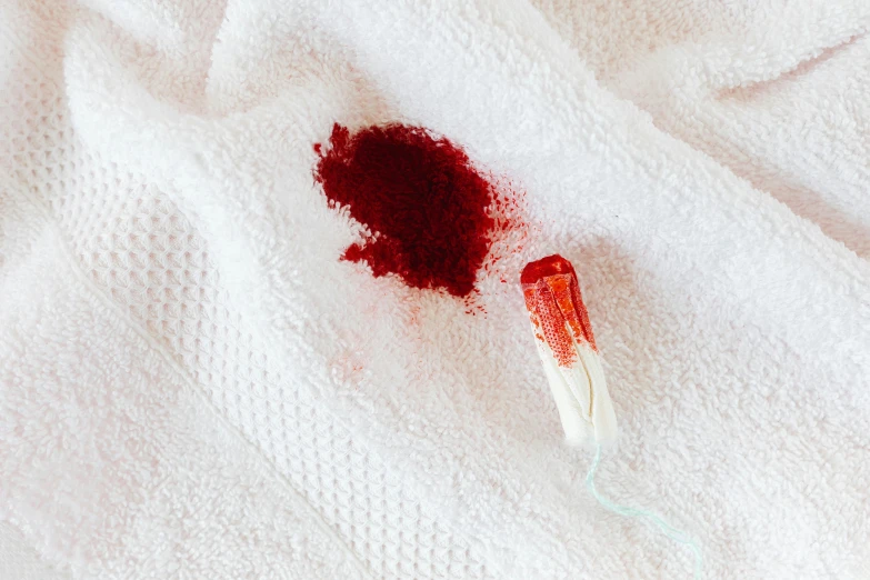 a toothbrush sitting on top of a white towel, by Elsa Bleda, trending on pexels, process art, made of blood, split hair dye, fabric embroidery, exploding powder