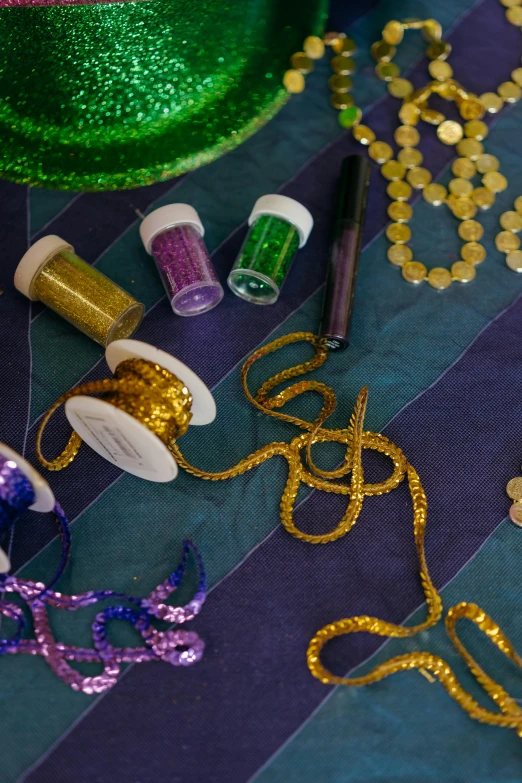 a green mardi gras hat sitting on top of a table, unsplash, process art, purple ribbons, various items, colors with gold and dark blue, spangle