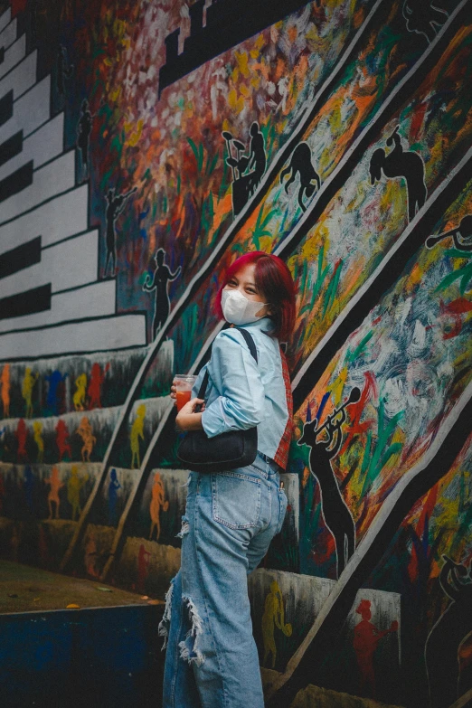 a woman standing in front of a wall covered in graffiti, trending on pexels, stairway, asia, woman with red hair, covid-19 as a human