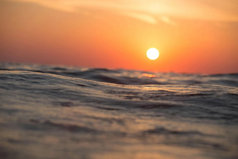 the sun is setting over a body of water, pexels contest winner, romanticism, rippling oceanic waves, horizon line focus, float, a close-up