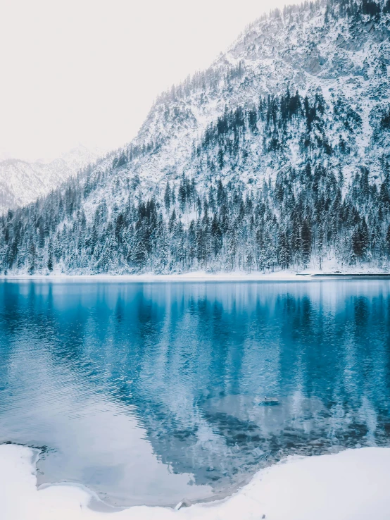 a large body of water surrounded by snow covered mountains, pexels contest winner, winter forest, high quality product image”, multiple stories, symmetrical image