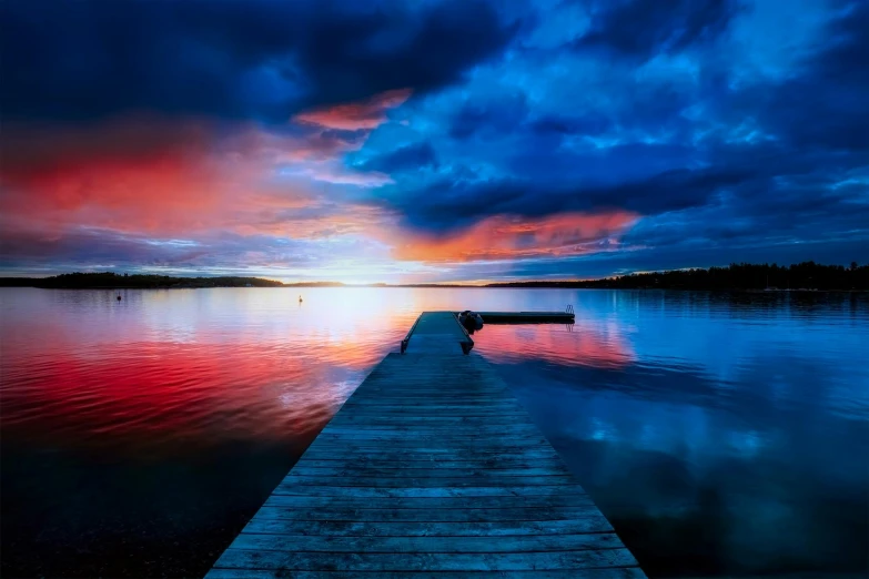 a dock sitting on top of a lake under a cloudy sky, by Peter Madsen, pexels contest winner, hurufiyya, red and blue back light, full colour, blue sunset, youtube thumbnail