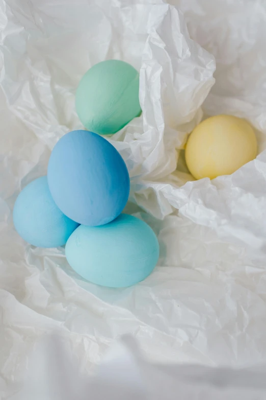 a bunch of eggs sitting on top of a white paper, modelling clay, soft cool colors, product shot, matte finish