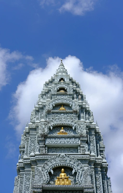 a tall tower with a clock on top of it, cambodia, light grey blue and golden, lead - covered spire, up-close