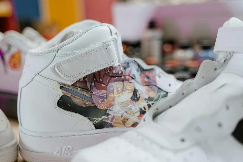 a close up of a pair of shoes on a table, an airbrush painting, inspired by Shunkōsai Hokushū, tumblr, process art, face covers half of the frame, air force, highly detailed in 4 k ”, anime cels