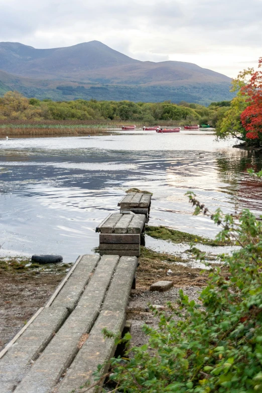 a wooden bench sitting next to a body of water, land art, mayo, 3 boat in river, october, overflowing