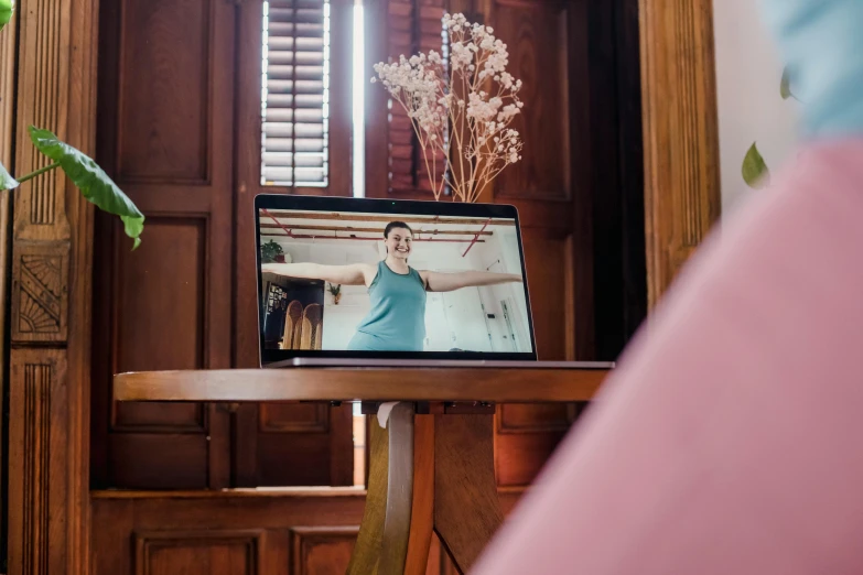 a laptop computer sitting on top of a wooden table, by Julia Pishtar, unsplash, video art, angel doing yoga in temple, view from behind mirror, joy ang, large screen