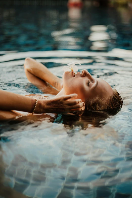a woman laying on her back in a pool, pexels contest winner, renaissance, beautifully soft lit, lips, liquid gold, resort