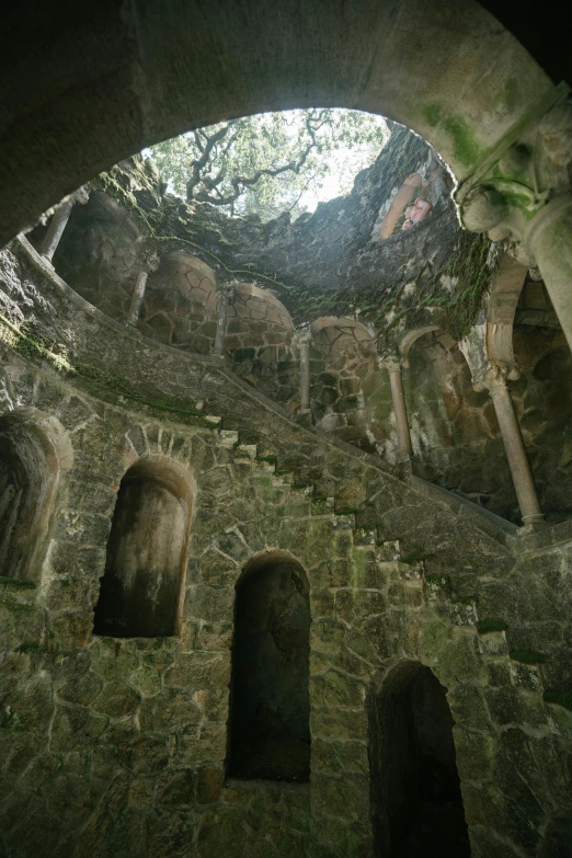 the inside of a stone building with a skylight, romanesque, las pozas, multiple stories, portugal, tombs
