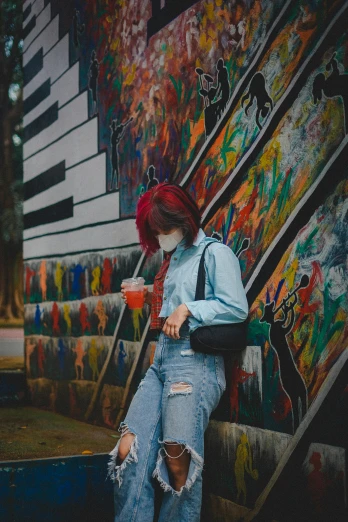 a woman with red hair leaning against a wall, a painting, trending on pexels, graffiti, drinking a coffee, walking to the right, multi colored, 2019 trending photo