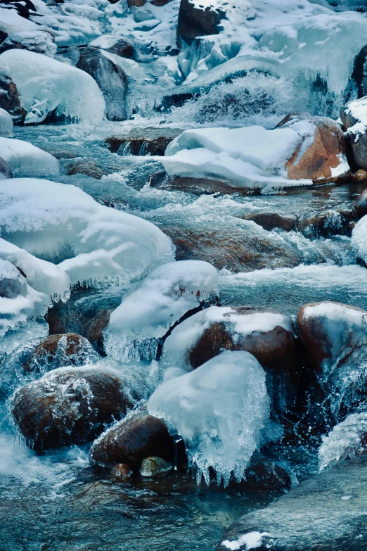 a stream running through a snow covered forest, inspired by Edward Willis Redfield, trending on unsplash, boulders, 8k detail, ice seracs, rapids